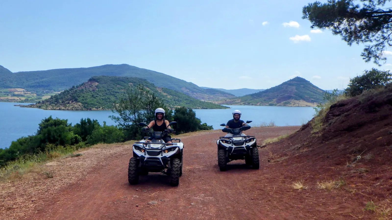 Deux quads sur une piste de terre rouge au-dessus du lac du Salagou