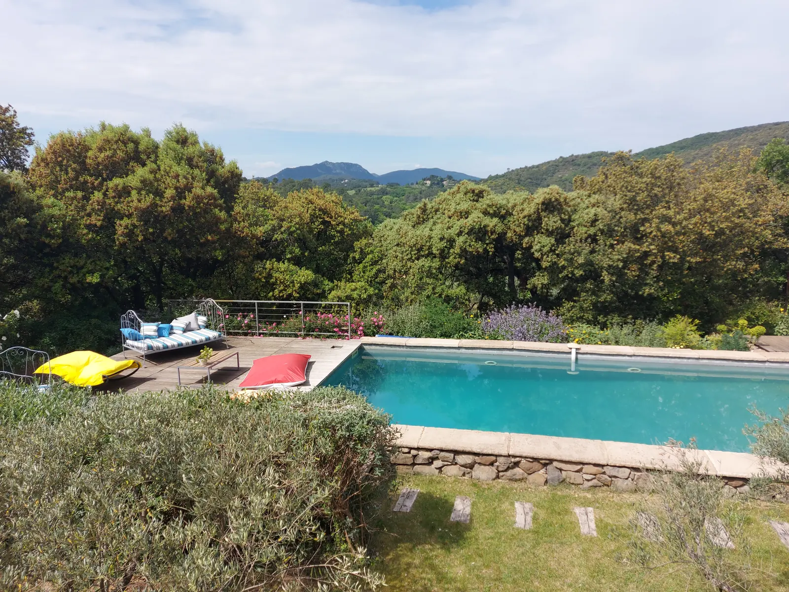Piscine et terrasse en bois du gîte, face aux collines